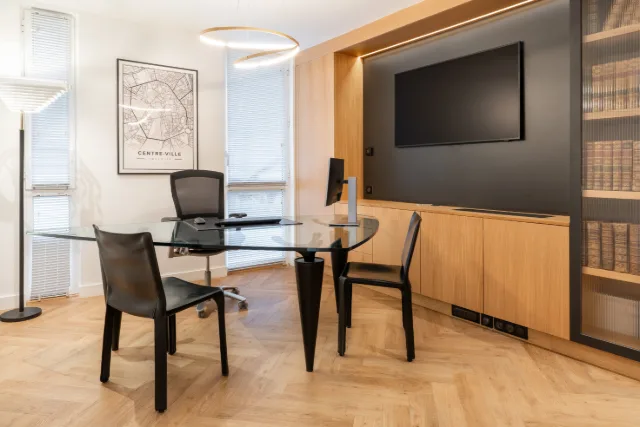 Bureau à plateau de verre sous suspension annulaire allumée, téléviseur et rangements en chêne éclairés